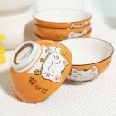 Bols orange Maneki Neko présentés sur une table.