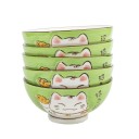 Cinq bols verts en porcelaine à motif Maneki Neko empilés.